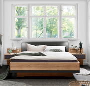 Modernes Futonbett aus Holz mit gepolstertem Kopfteil, umgeben von Nachttischen, in einem hellen Raum mit großen Fenstern, Vorderansicht