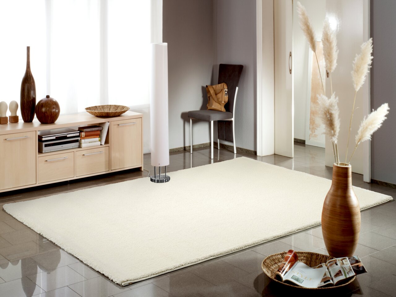 Heller Uni-Teppich in einem modernen Wohnzimmer, fotografiert aus einer seitlichen Perspektive. Der Raum ist mit stilvollen Dekorationen und Möbeln ausgestattet.