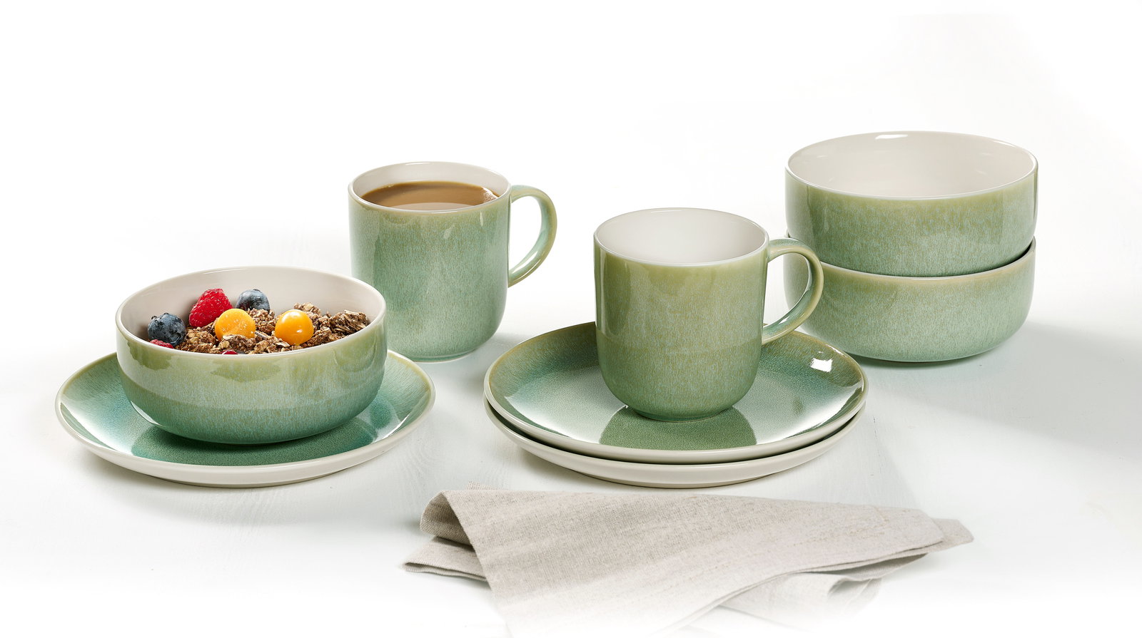 Frühstücksset 12-tlg. in sanftem Grün, bestehend aus Tassen, Schalen und Tellern, aus seitlicher Perspektive fotografiert.