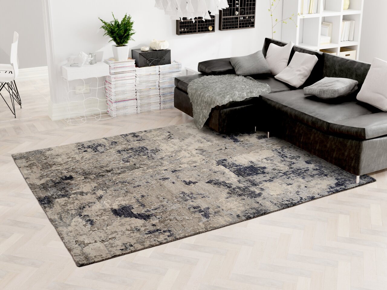 Moderner Designer-Teppich in einem stilvollen Wohnzimmer, mit einer grauen und blauen Musterung, neben einem dunklen Ecksofa. Perspektive von oben.