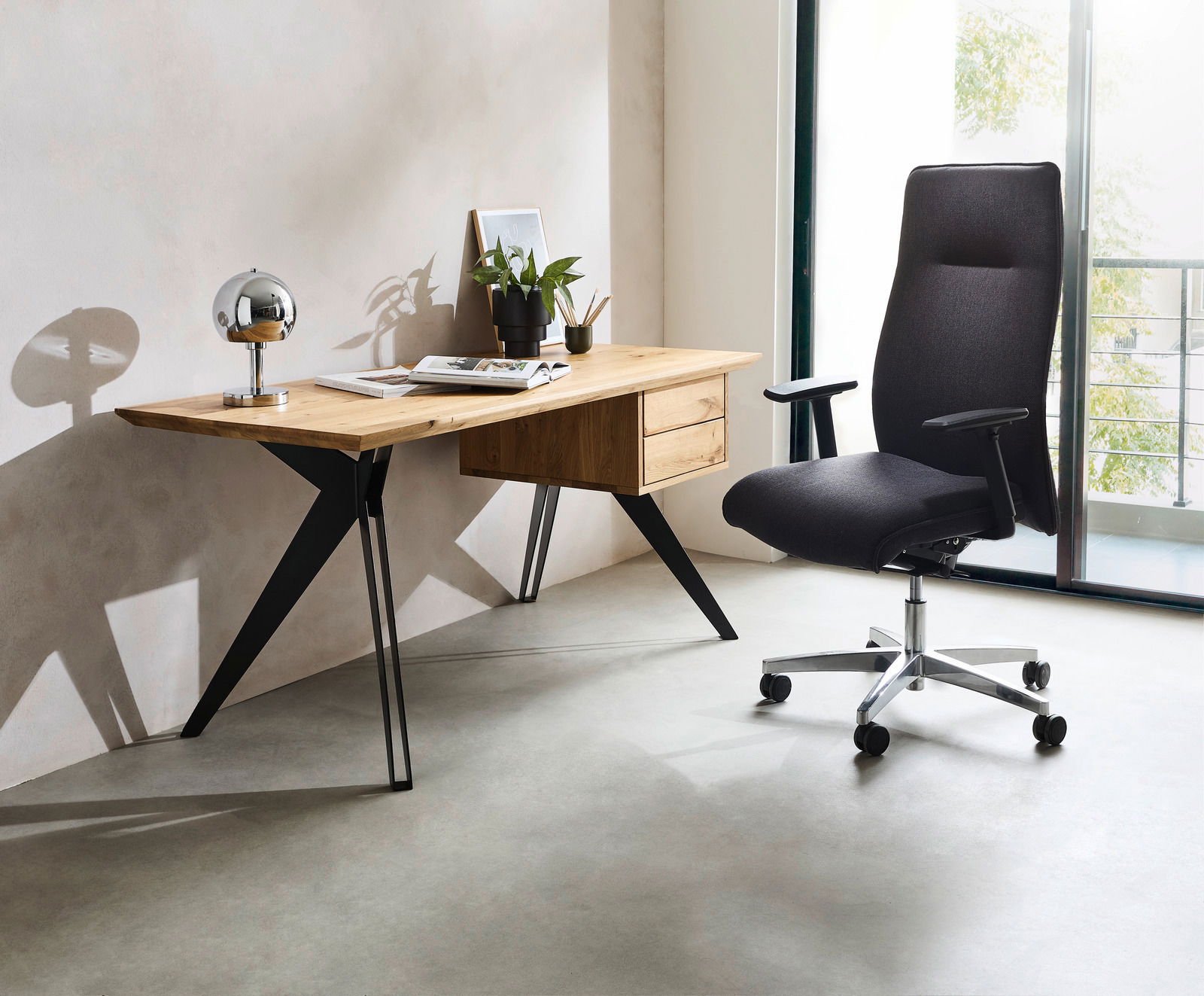 Linea Natura Schreibtisch ALINA Moderner Schreibtisch aus Holz mit schwarzen Metallbeinen, dekoriert mit einer Lampe, Pflanzen und Büchern, seitliche Perspektive.