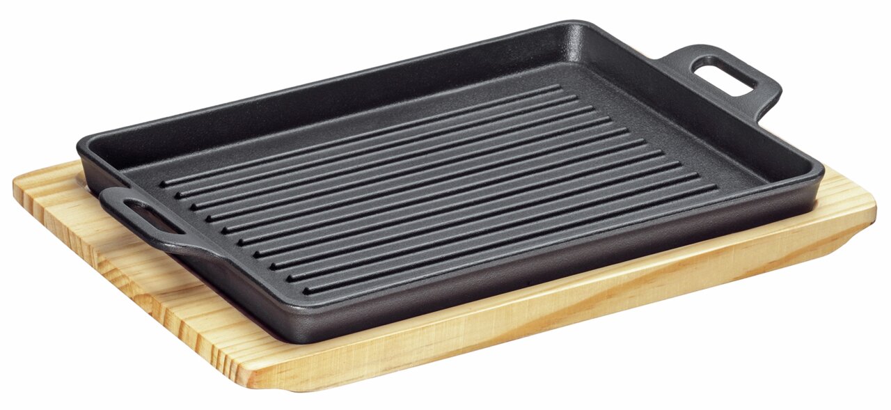 Rechteckige Grillplatte aus Gusseisen mit Rillen, präsentiert auf einem Holzbrett, seitliche Perspektive.