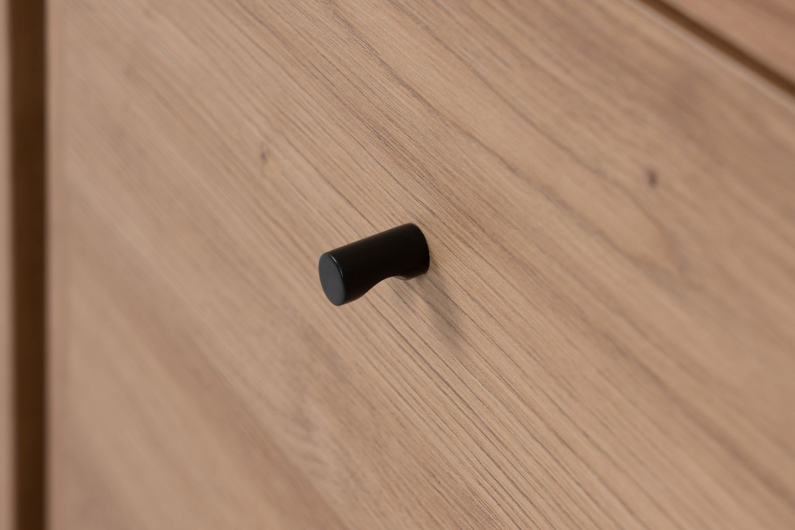 Nahaufnahme eines Holzschranks mit schwarzem Griff, seitliche Perspektive