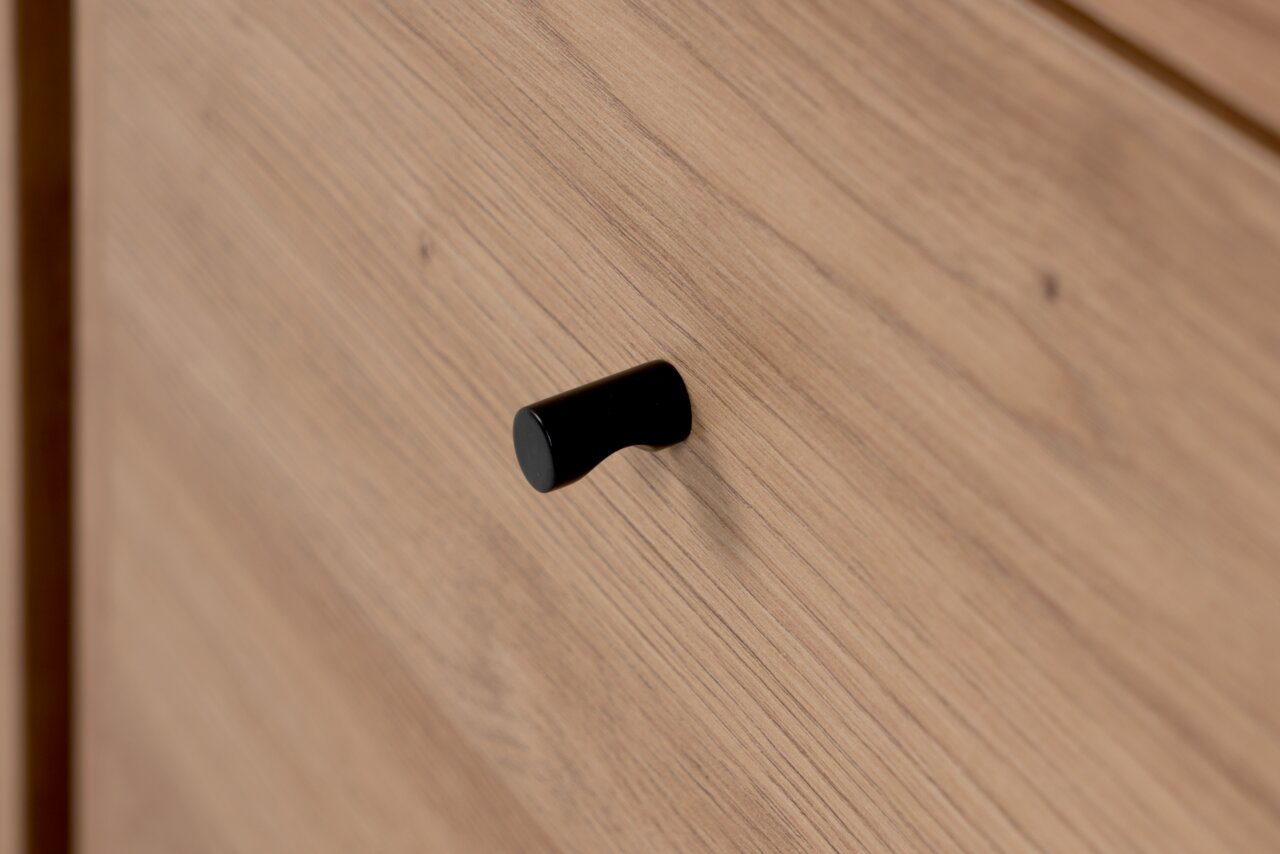 Nahaufnahme eines Holzschranks mit schwarzem Griff, seitliche Perspektive