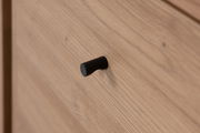 Nahaufnahme eines Holzschranks mit schwarzem Griff, seitliche Perspektive