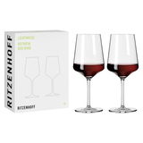 Zwei elegante Rotweingläser im Set, gefüllt mit Rotwein, neben der Verpackung mit der Aufschrift 'Ritzenhoff Lichtweiss Rotwein'. Frontalansicht.