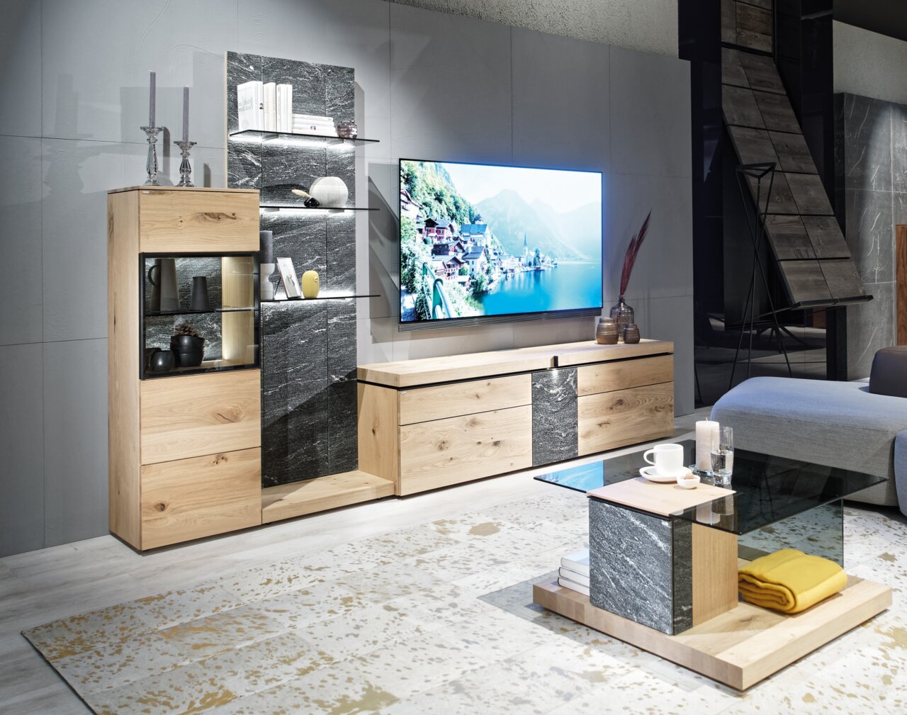 Moderne Wohnwand und Couchtisch in Holz- und Steinoptik, seitliche Perspektive