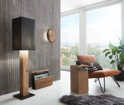 Moderne Wanduhr aus Holz an einer vertäfelten Wand, seitliche Perspektive.