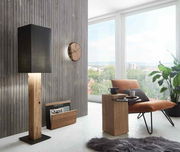 Moderne Wanduhr aus Holz an einer vertäfelten Wand, seitliche Perspektive.