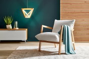 Moderner Sessel mit Holzrahmen und hellgrauem Polster, dekoriert mit einer türkisfarbenen Decke, in einem stilvollen Wohnzimmer mit hölzernem Wandpaneel und hängender Lampe, seitliche Perspektive.