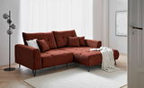 Rote Eckcouch mit Ottomane rechts, dekoriert mit Kissen und Decke, in einem modernen Wohnzimmer mit hellem Holzboden und Stehlampe, Perspektive von vorne links.