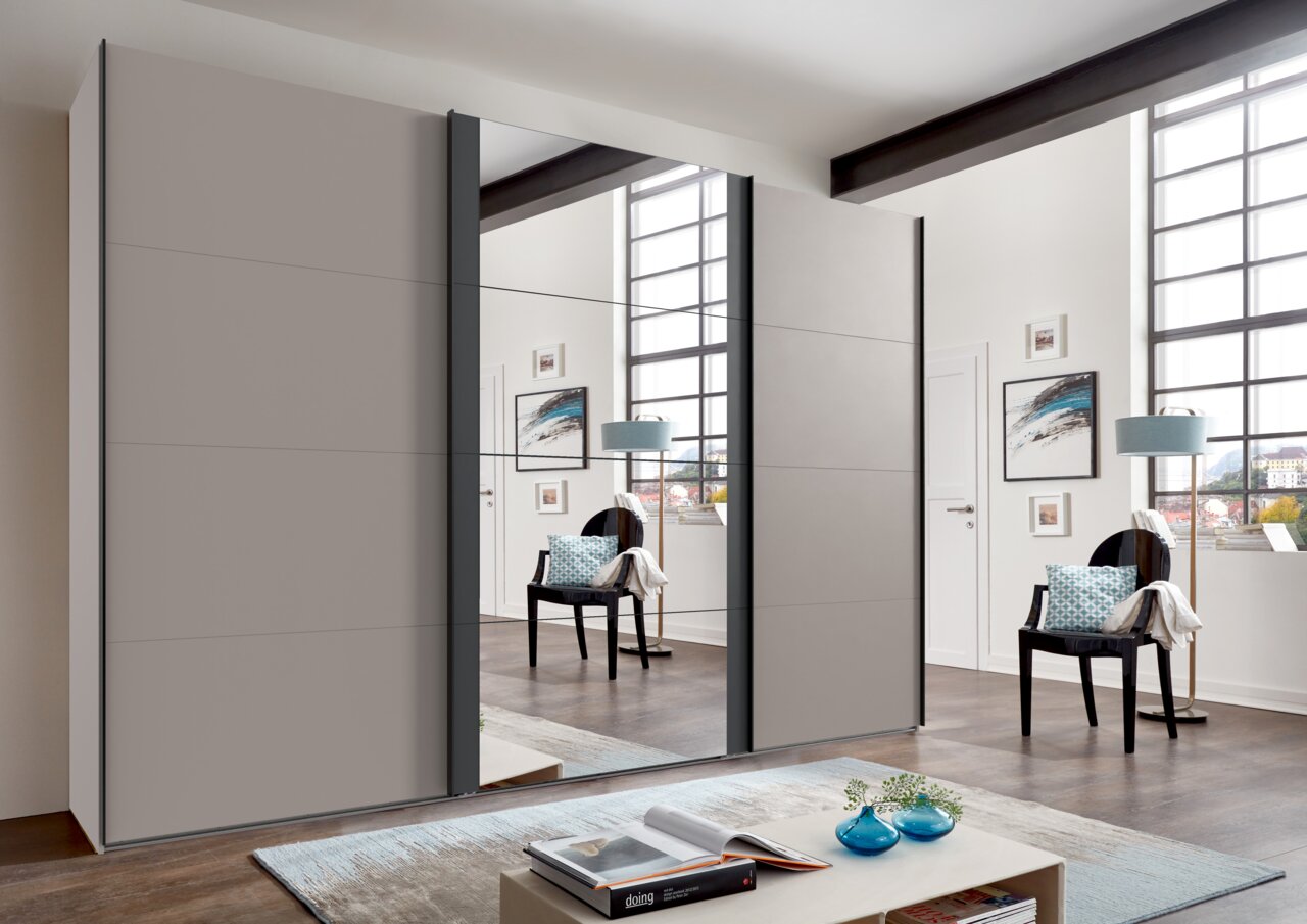 Moderne drievleugelige hangdeurkast met spiegel in een stijlvol ingerichte ruimte, zijaanzicht.
