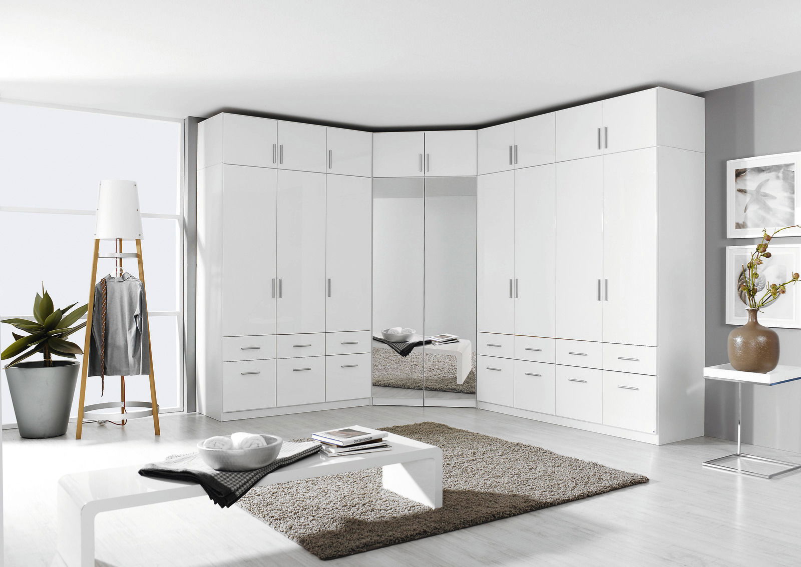 Eckschrank mit weißen Drehtüren und Schubladen, perspektivisch von vorne links fotografiert.