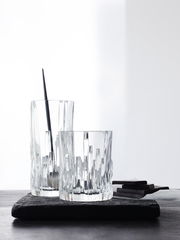 Zwei Longdrinkbecher Shu Fa aus Kristallglas mit modernem, geometrischem Design, auf einer dunklen Unterlage stehend, seitliche Perspektive.