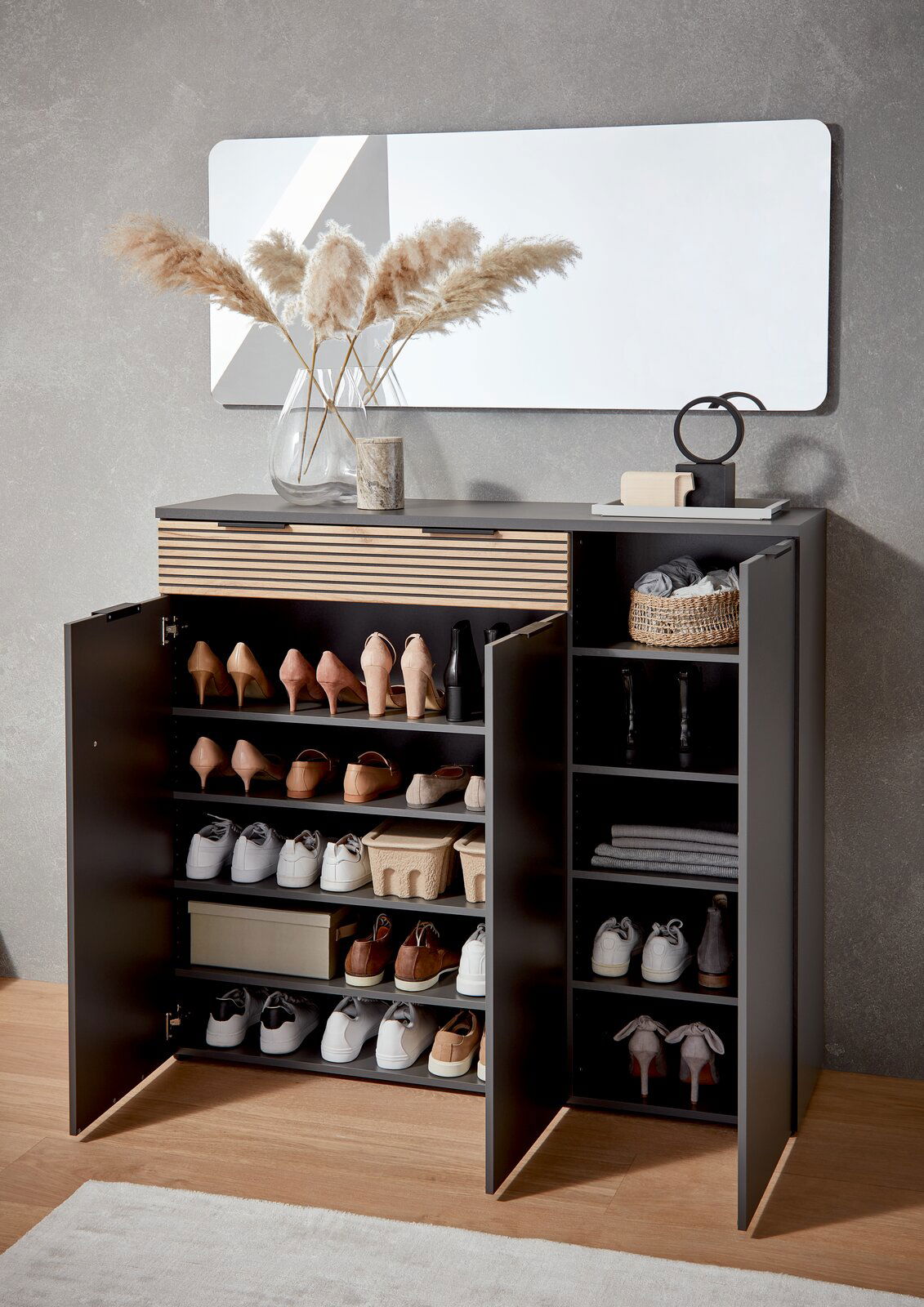 Moderner Schuhschrank mit offenen Türen, gefüllt mit verschiedenen Schuhen und Accessoires, aus der Frontalperspektive fotografiert.