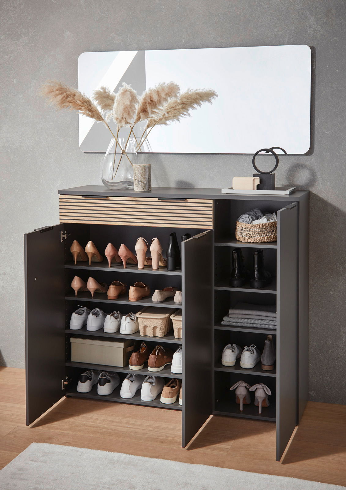 Moderner Schuhschrank mit offenen Türen, gefüllt mit verschiedenen Schuhen und Accessoires, aus der Frontalperspektive fotografiert.