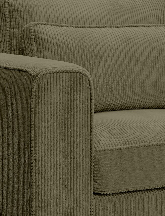 Nahaufnahme eines olivgrünen Cord-Sofas mit geripptem Bezug, sichtbarer Armlehne und Sitz-/Rückenkissen, fotografiert aus schräger Seitenperspektive