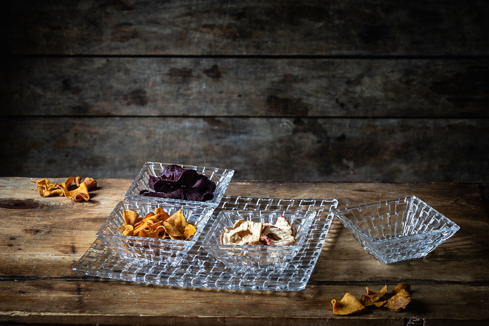 Servier-Set Bossa Nova 5-tlg. aus Glas mit vier Schalen und einem Tablett, gefüllt mit verschiedenen Snacks, auf einem rustikalen Holztisch aus der Vogelperspektive.