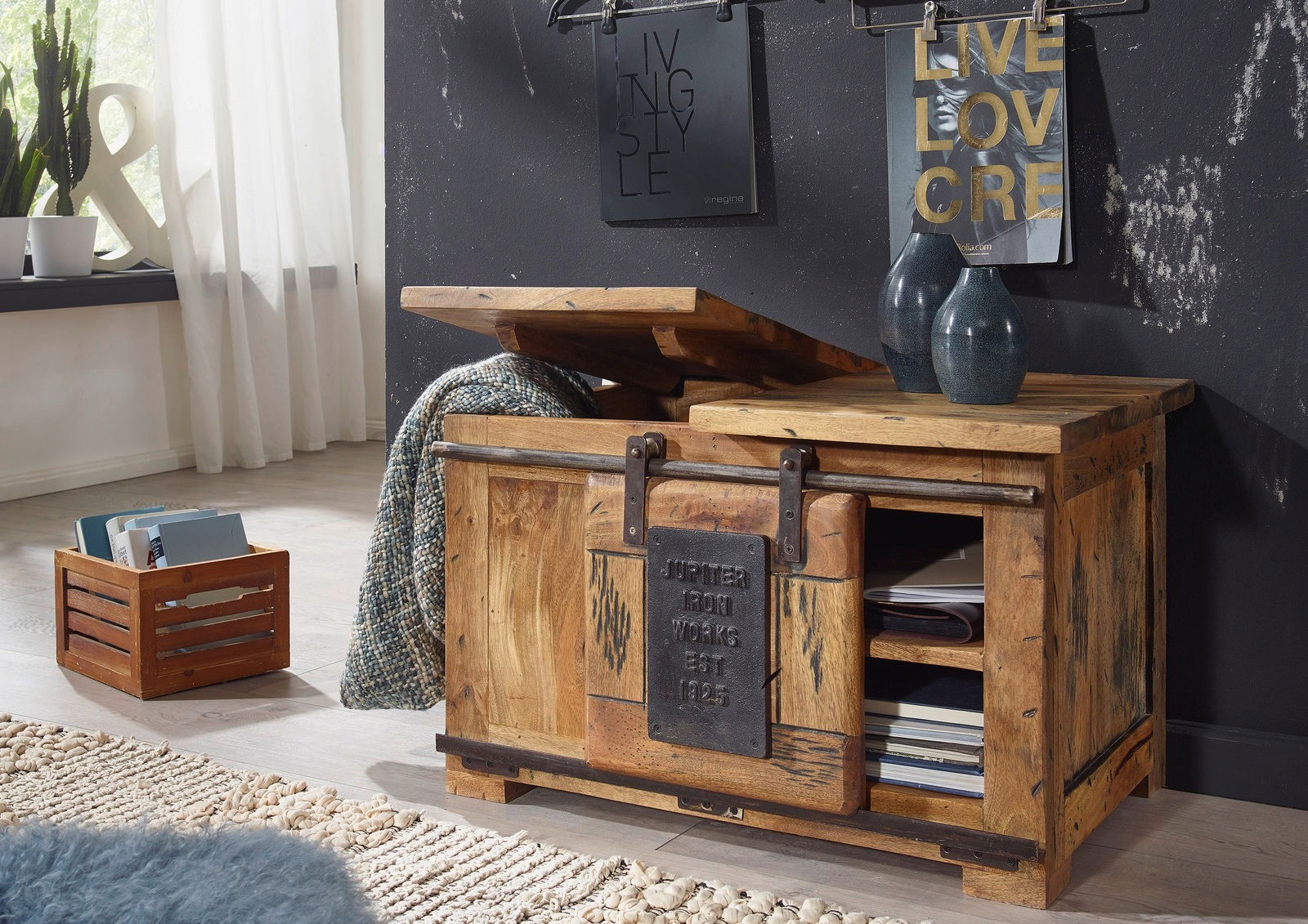 Rustikales TV-Board aus Holz mit aufklappbarer Truhe, seitliche Perspektive, dekoriert mit Vasen und Zeitschriften.