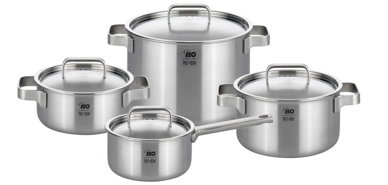 Vierteiliger Topfset aus Edelstahl, bestehend aus drei Töpfen und einer Stielkasserolle, mit Deckeln, aus der Perspektive leicht von oben fotografiert.