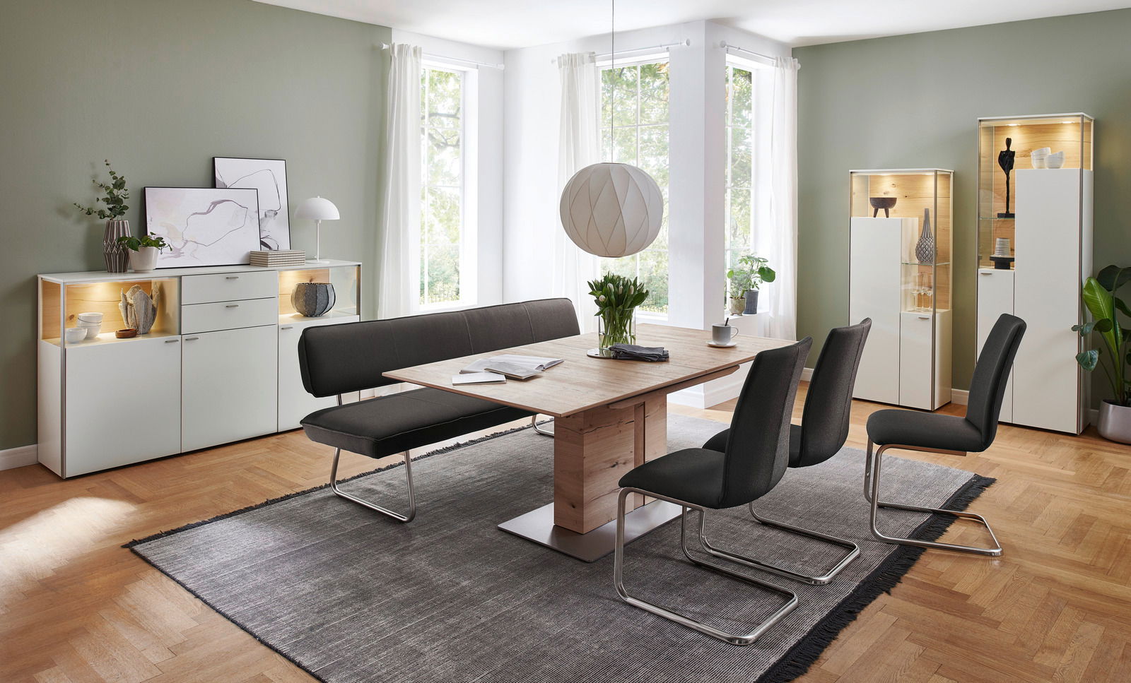 Moderner Esstisch aus Holz mit schwarzer Sitzbank und Stühlen in einem hellen Esszimmer, seitliche Perspektive