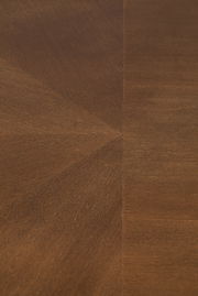 Nahaufnahme der Holzmaserung eines Esstisches aus dunklem Holz, von oben betrachtet.