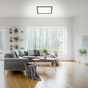 Moderne LED-Deckenleuchte in einem stilvollen Wohnzimmer, von unten betrachtet.