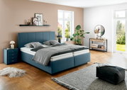 Modernes Polsterbett in einem stilvoll eingerichteten Schlafzimmer, seitliche Perspektive