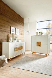 Modernes Highboard und Sideboard in einem hellen Raum mit Holzwand und großen Fenstern, seitliche Perspektive.