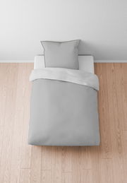 Graue Bettwäsche 155x220cm auf einem Bett, von oben fotografiert, auf hellem Holzboden.
