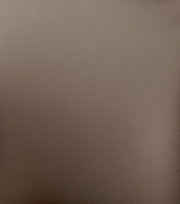 Nahaufnahme der braunen Lederstruktur eines Barstuhls.