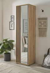Moderner Garderobenschrank aus Holz mit Spiegel, seitliche Perspektive, dekoriert mit Pflanzen und Wandkunst.