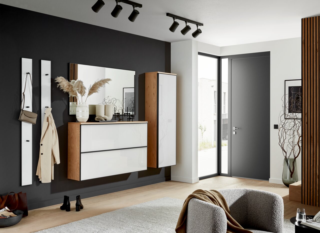 Moderner Eingangsbereich mit Hängeschuhschrank, Spiegel und Garderobenpaneel in einer stilvollen, hellen Wohnung. Perspektive von der Seite.