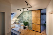 Moderne Wohnzimmerecke mit stilvoller Beleuchtung, Holzboden und dekorativer Wandgestaltung aus der Perspektive eines erhöhten Blickwinkels.