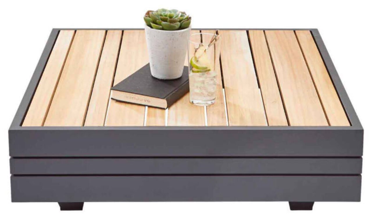 Moderne salontafel met een blad van houten latten, versierd met een boek, een glas met een drankje en een klein plantje, gezien vanuit het vooraanzicht.
