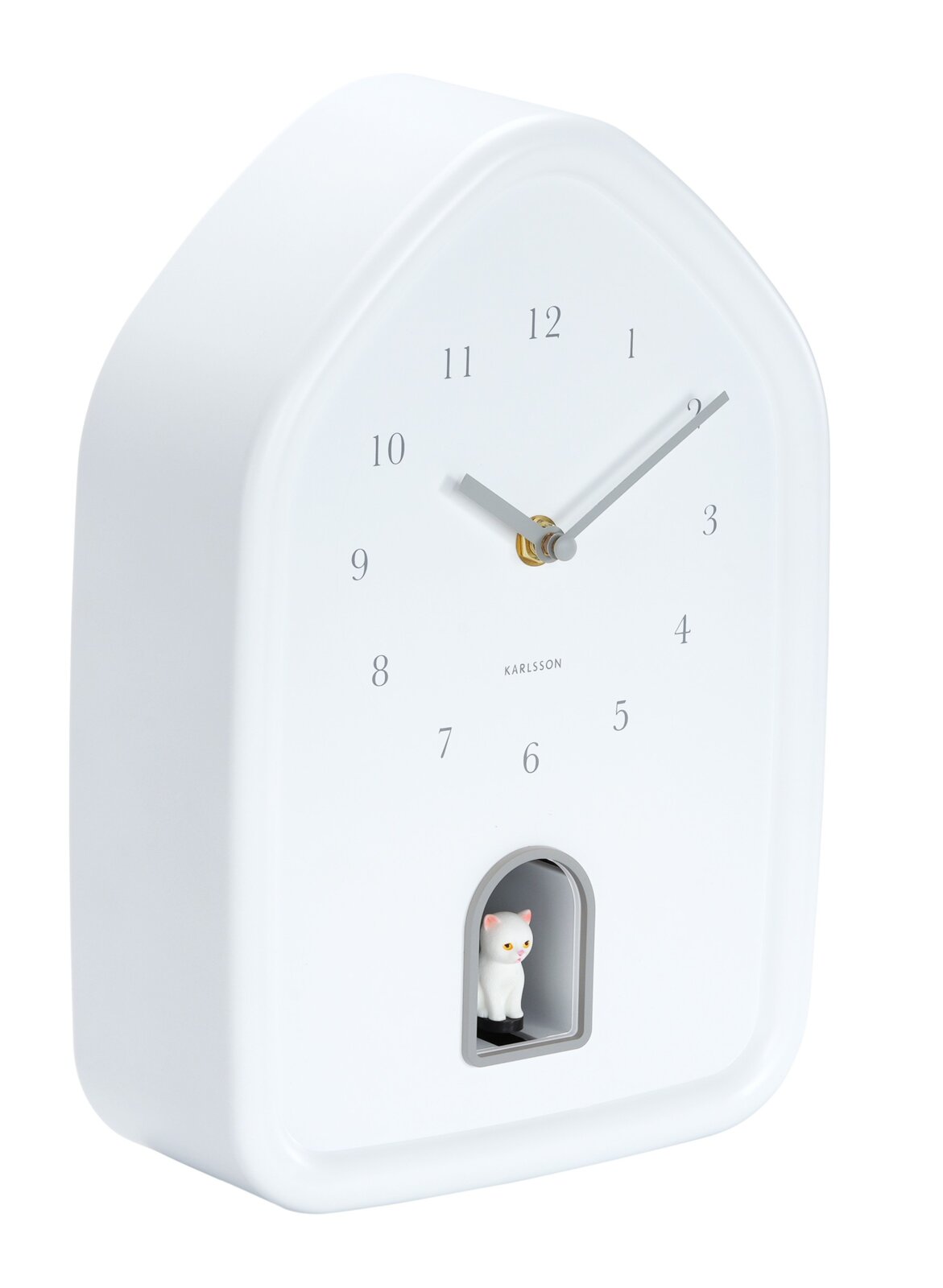Weiße Wanduhr in Hausform mit minimalistischen Ziffern und einer kleinen Katzenfigur in einer Öffnung unten, seitliche Perspektive.