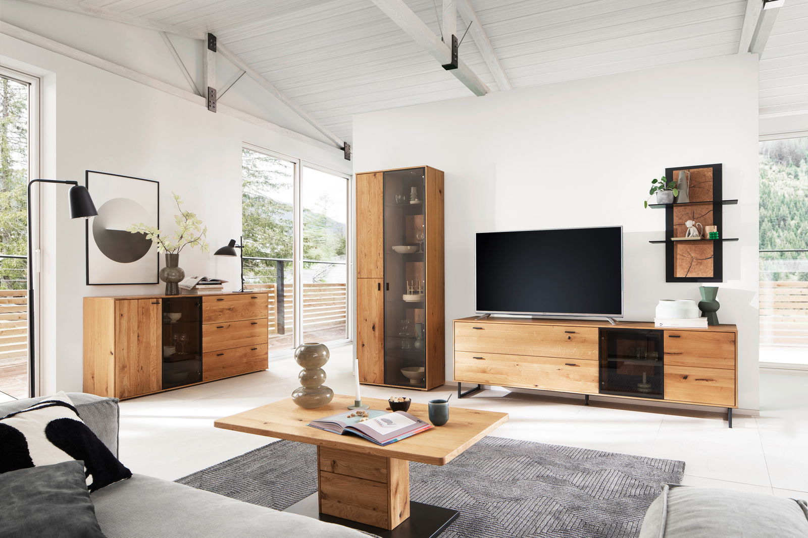 Moderner Couchtisch aus Holz in einem hellen Wohnzimmer, frontal von vorne fotografiert, umgeben von stilvollen Möbeln und großen Fenstern mit Blick ins Grüne.