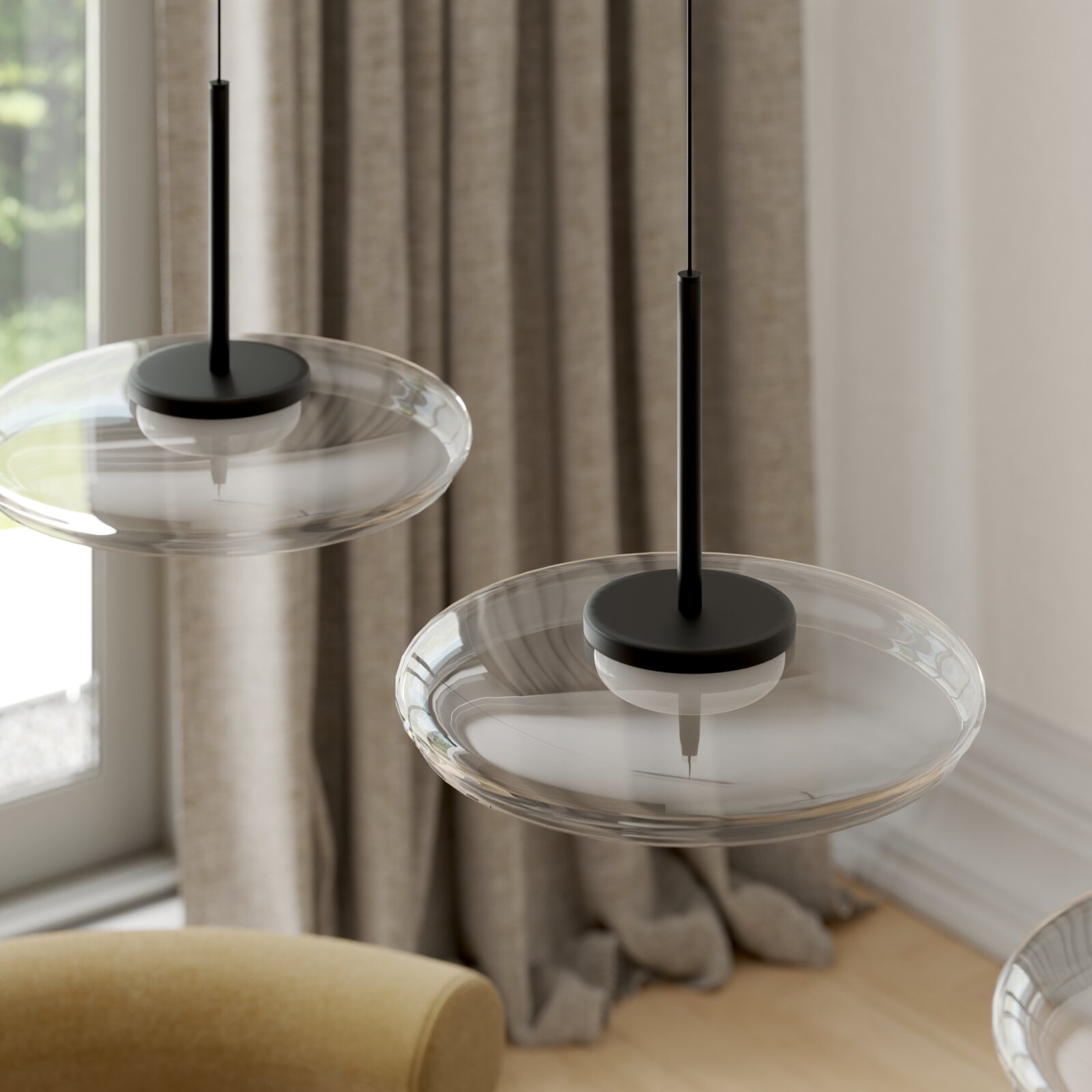 Zwei moderne Pendelleuchten mit flachem, transparentem Glasschirm und schwarzer Aufhängung, in leicht schräger Seitenansicht im Wohnraum vor Vorhängen