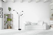 Moderne Stehleuchte mit fünf verstellbaren Armen in einem hellen Wohnzimmer, seitliche Perspektive.
