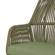 Nahaufnahme eines Gartensessels mit geflochtenem Design und grünem Sitzkissen, seitliche Perspektive