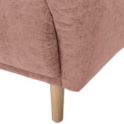 Nahaufnahme einer Rundecke mit rosa Stoffbezug und hellem Holzbein, Perspektive von der Seite.