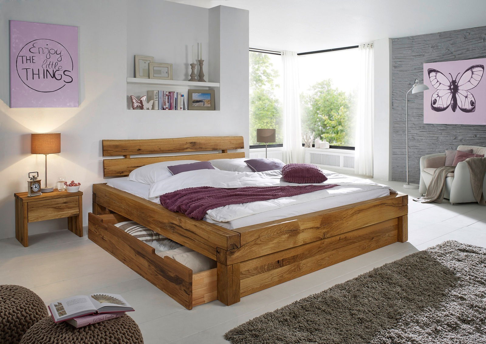 Holzbett mit Schubladen und passender Nachtkommode in einem modernen Schlafzimmer, seitliche Perspektive