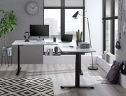 Moderner E-Eckschreibtisch in einem stilvollen Büro mit Blick auf große Fenster, ausgestattet mit Computer, Lampe und Pflanzen.