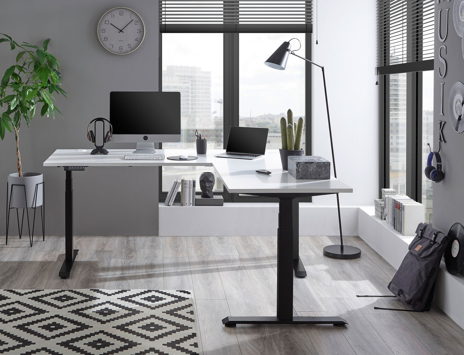 Moderner E-Eckschreibtisch in einem stilvollen Büro mit Blick auf große Fenster, ausgestattet mit Computer, Lampe und Pflanzen.