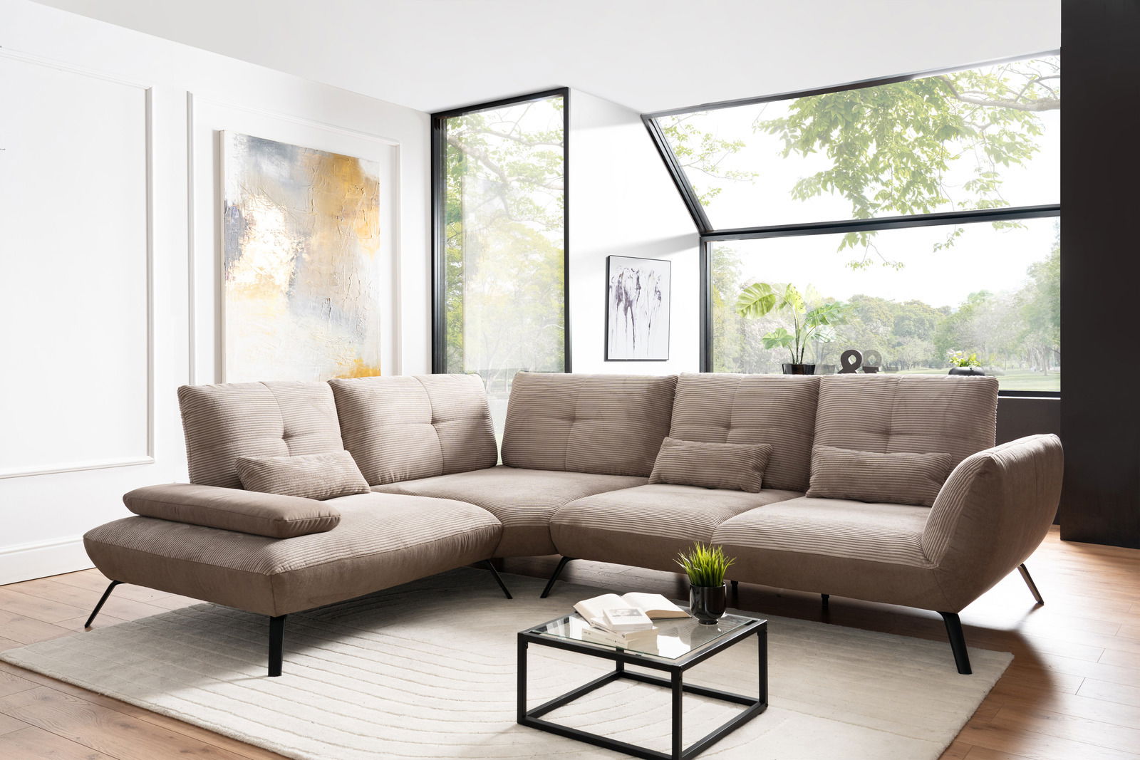 Beige Ecksofa in modernem Wohnzimmer mit großen Fenstern, von vorne betrachtet.