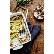 Servierlöffel NUOVA 25CM in einer Auflaufform mit Zucchini-Auflauf, von oben fotografiert.