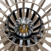 Close-up van een tafellamp van bovenaf, waarop het ontwerp met concentrische cirkels en een centrale gloeilamp te zien is.
