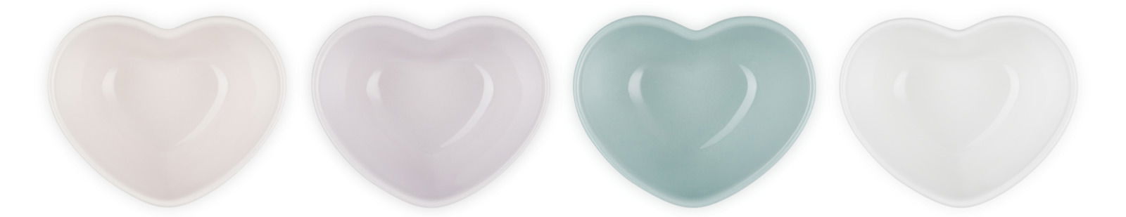 Vier herzförmige Schälchen in Pastellfarben, von oben betrachtet.