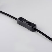 Schwarzer Schnur-Zwischenschalter (Ein/Aus) an einem textilummantelten Kabel, Nahaufnahme in leicht schräger Seitenansicht auf hellem Hintergrund