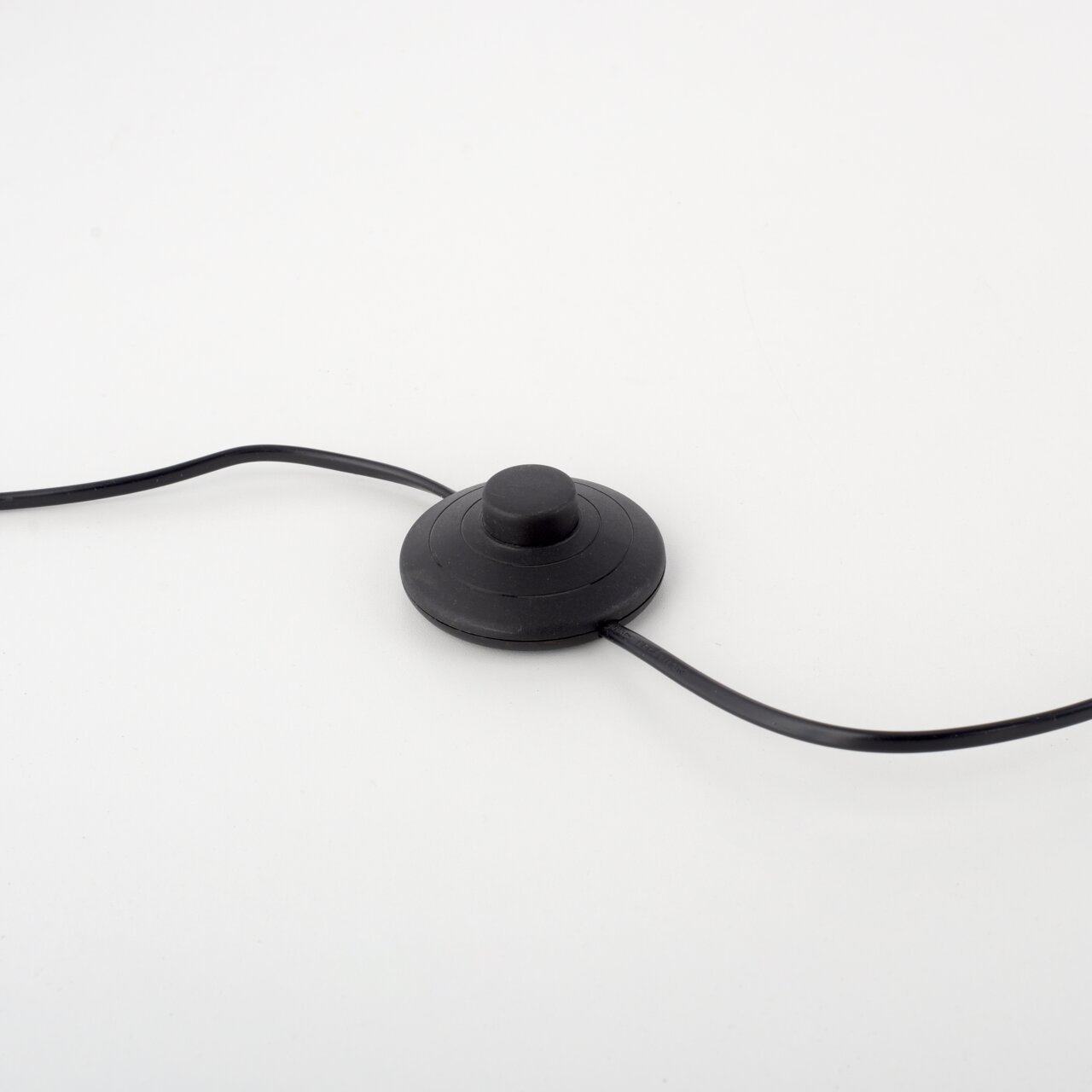 Nahaufnahme eines schwarzen Fußschalters mit Kabeln, Teil der Stehleuchte PURE-MIRA.